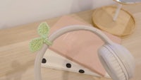a pair of headphones with a crocheted leaf on them