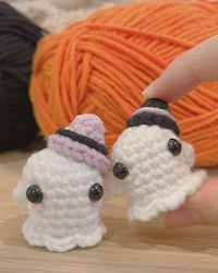 two crocheted ghosts sitting next to each other